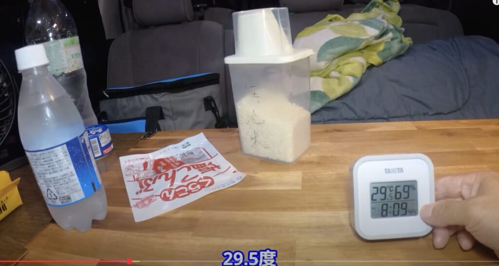車内で食事を作るときに窓を開けて換気しているが車内の温度が暑く厳しい様子