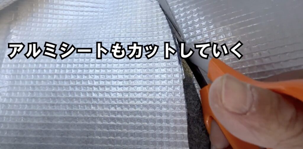 有孔ボードの枠に合わせて断熱用アルミシートをカットしていくシーン