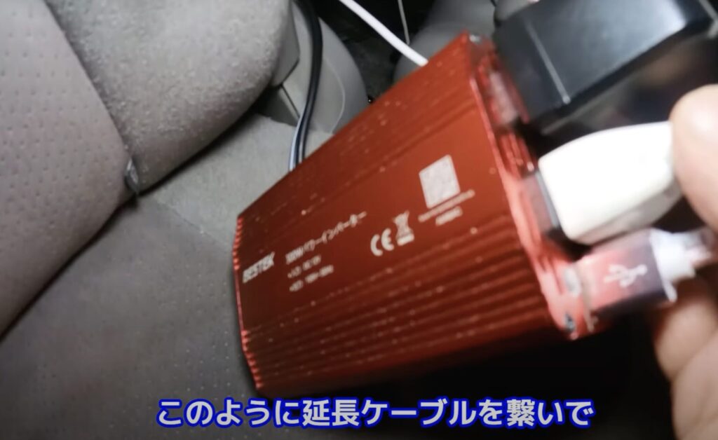 シガーソケットから取った電気をインバーターで100vに変えてコンセントを取っているシーン