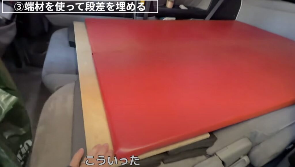端材の木材やクッション材を使って隙間を埋めてベッドを安定化させているシーン