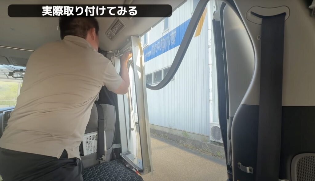 窓用エアコンのアタッチメントを取り付けてるシーン