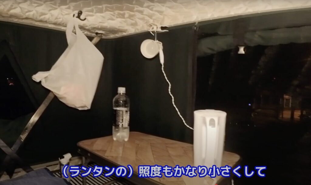 テント内で机を出して食事しながらくつろいでいる