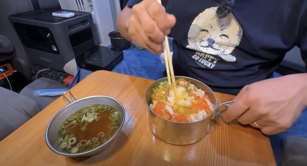 内で食べる、卵とネギが乗った豪華な海鮮のっけ丼