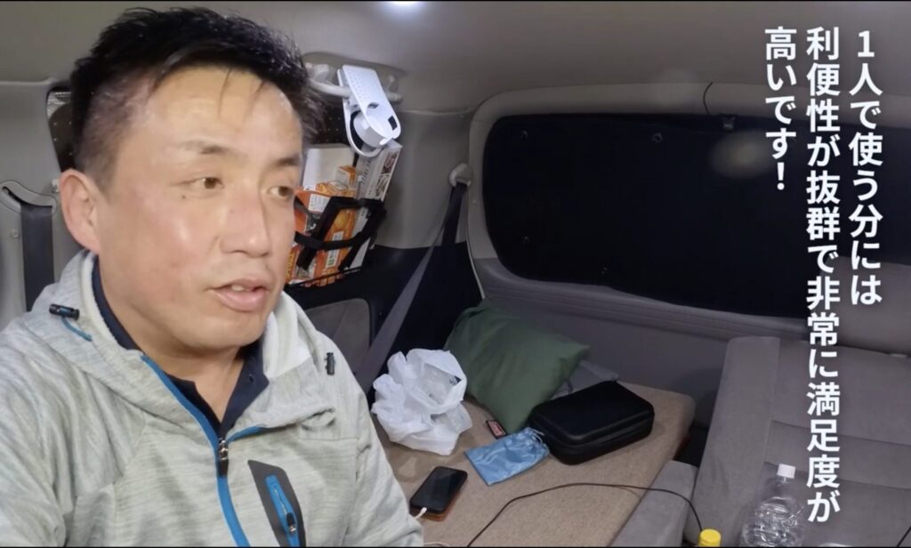 DIYによってアルファードの車内に設置された常設の木製テーブルと、その後方に配置されたベッドスペース