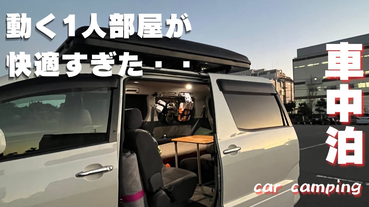 「動く1人部屋が快適すぎた…」という文字と「車中泊 car camping」の文字。夜、室内灯が灯り、快適そうな車内が見えるアルファードの外観。ルーフボックスも搭載されている。