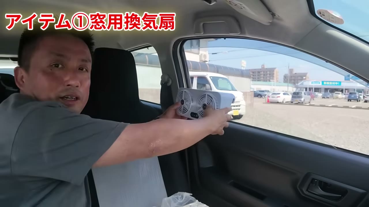 窓用換気扇をミライースの窓に引っ掛けて設置しているところ